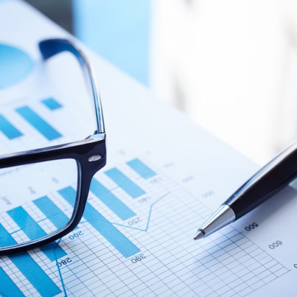 Close-up view of eyeglasses, pen, and financial report placed together