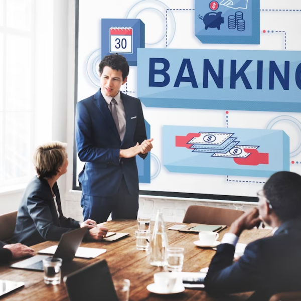 A group of people in a meeting, with one person standing and discussing and the term 'banking' is on the screen