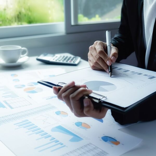 A man in an office holding a pan and a chart