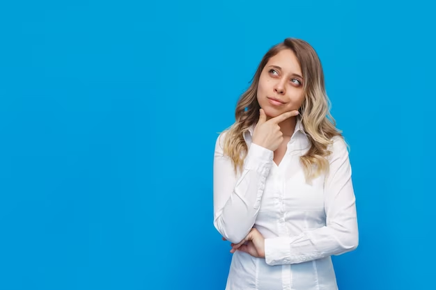 woman gazing upwards and to the side while holding her chin