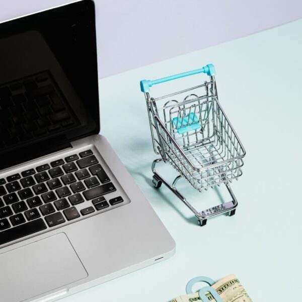 Laptop, cart and pack of dollars.