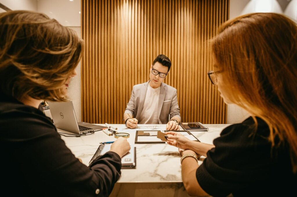 two girls discussing a business plan with a man.