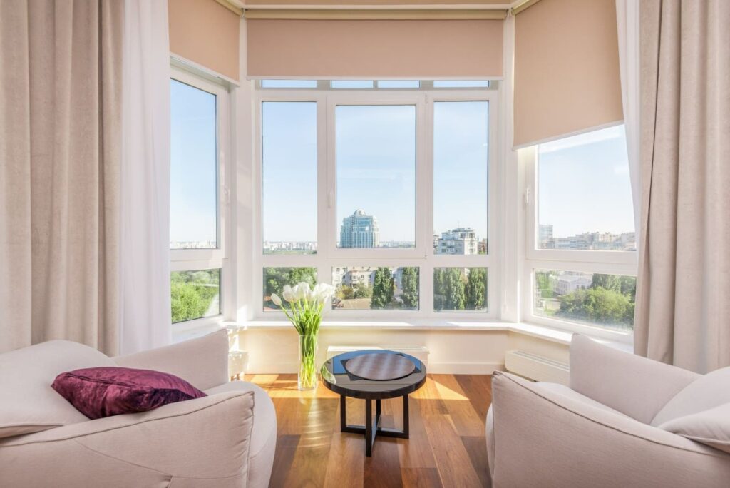 Sunny room with 2 chairs, a table, and flowers