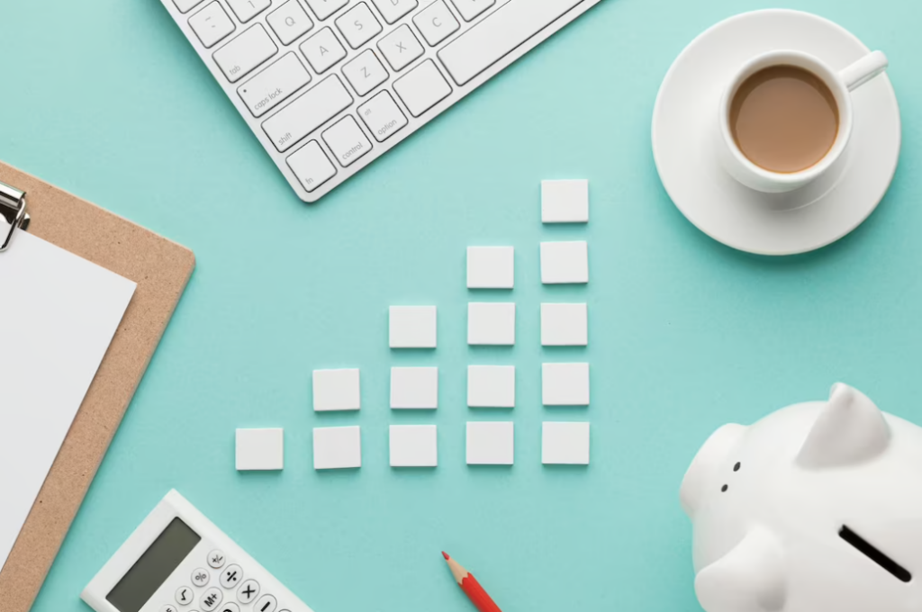 piggy bank, pencil, calculator, coffee, and keyboard on turquoise table